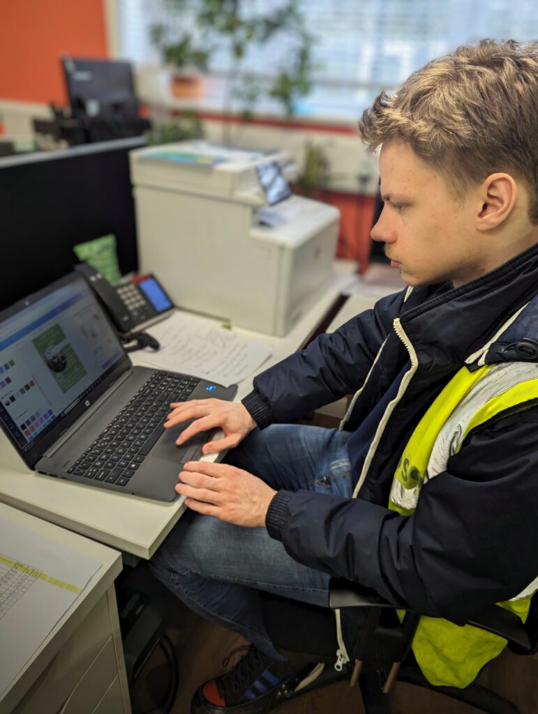 A FareChance participant works at a laptop, doing admin.