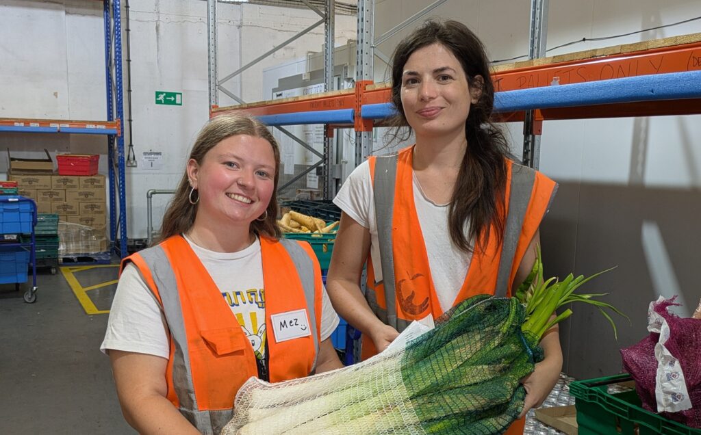 Two team members with a very big net of leeks